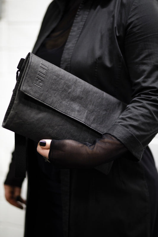 Fiilii design melna clutch somiņa sievietes rokās 